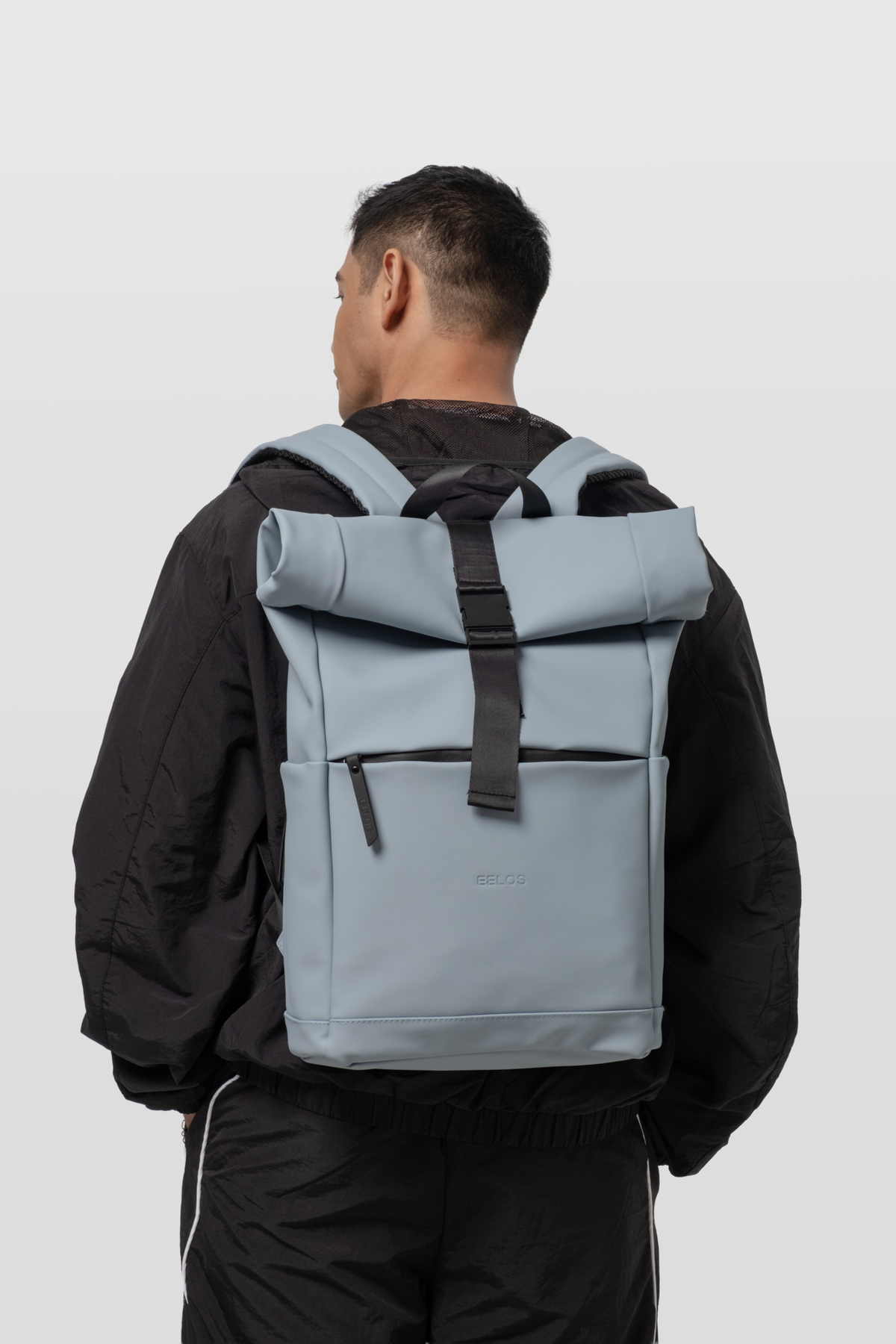Person wearing a gray backpack on a white background
