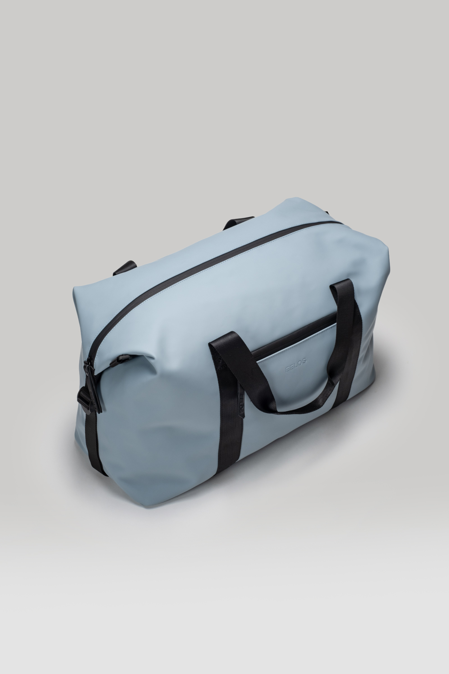 Light blue duffel bag with black straps on a light gray background