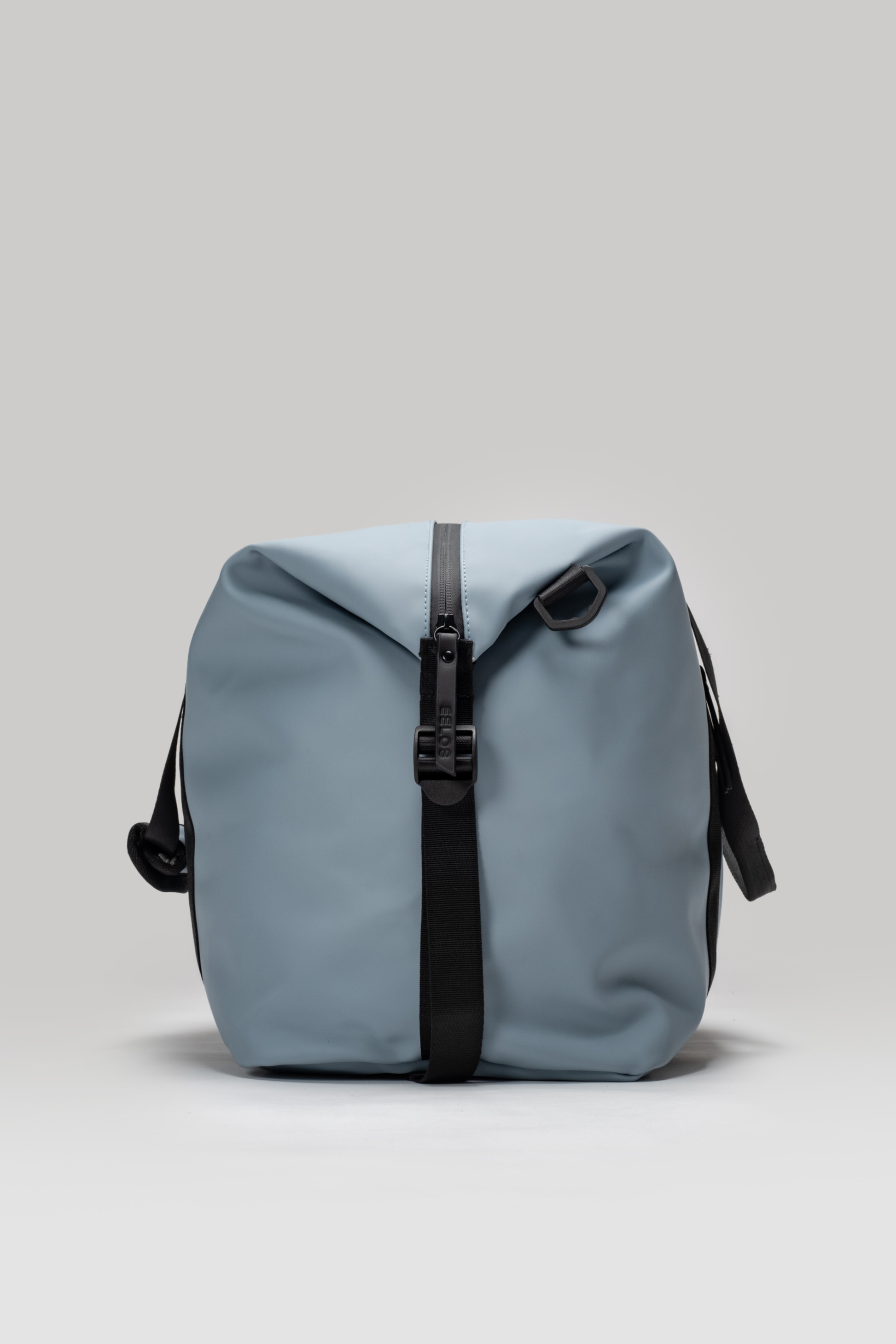 Light blue backpack with black straps on a light gray background