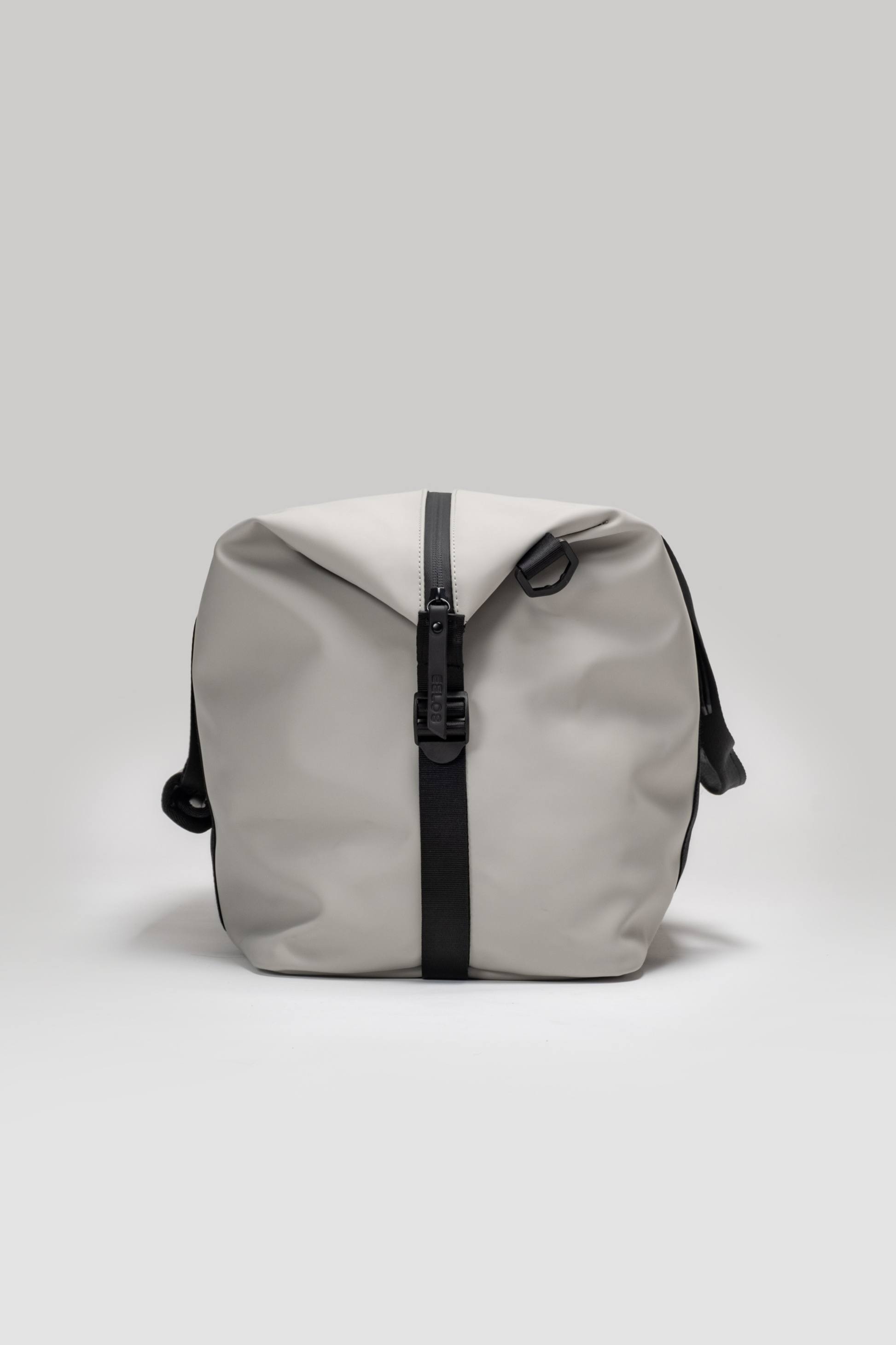 Gray backpack with a black zipper on a light gray background