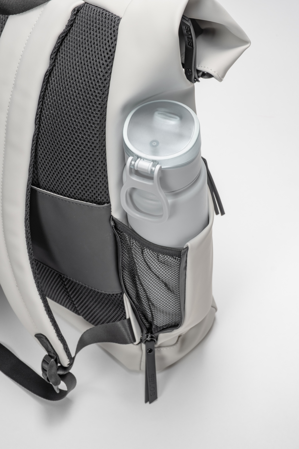 Backpack with a water bottle in a dedicated pocket on a white background