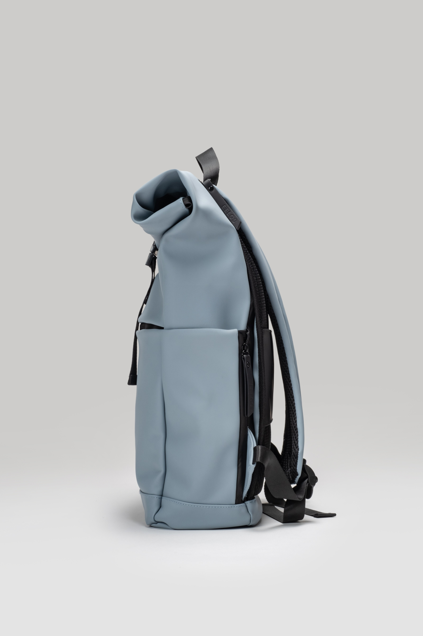 Light blue backpack with black straps on a light gray background