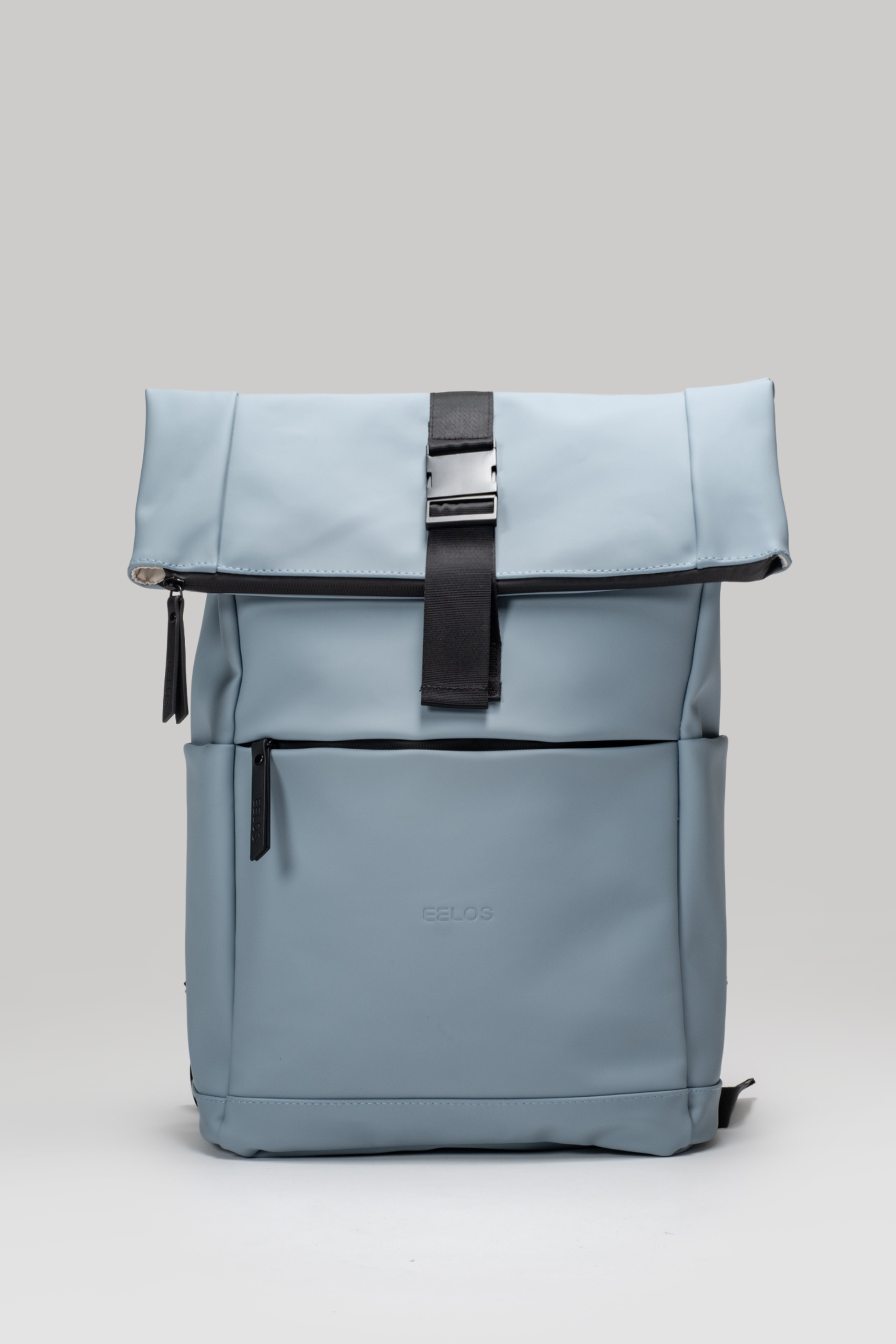 Light blue backpack with a black strap on a light gray background