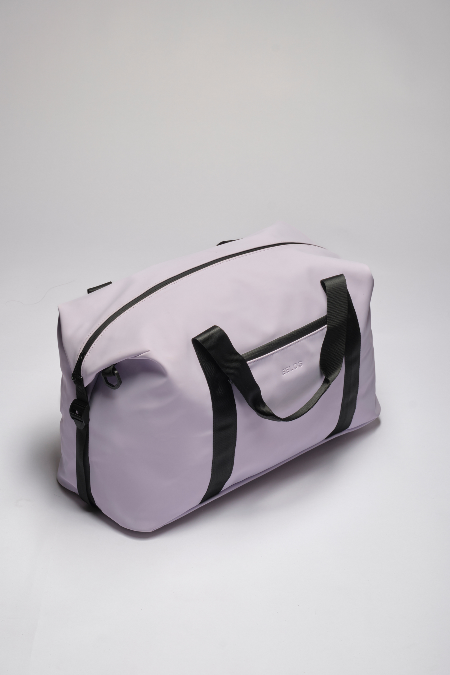 A light purple duffel bag with black handles and trim, photographed on a neutral light gray background.