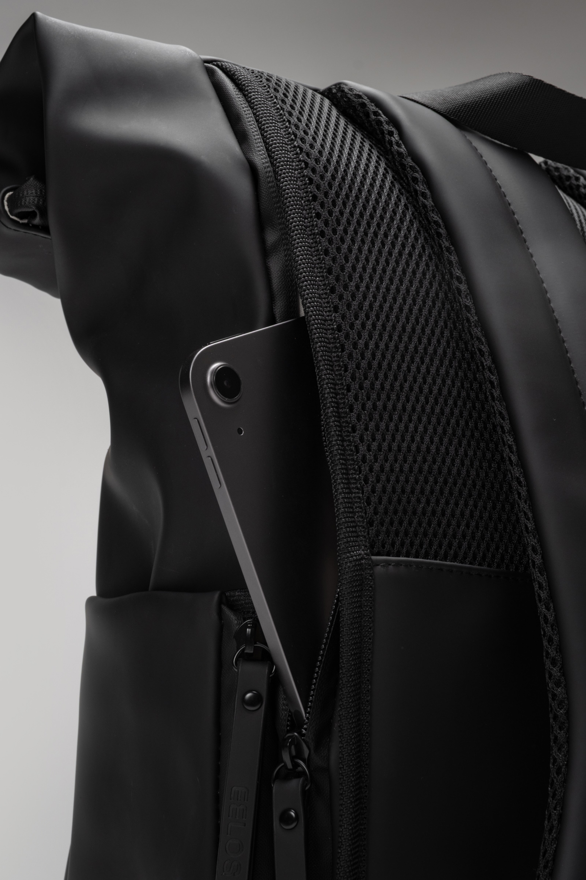 Close-up of a black backpack with a gray background